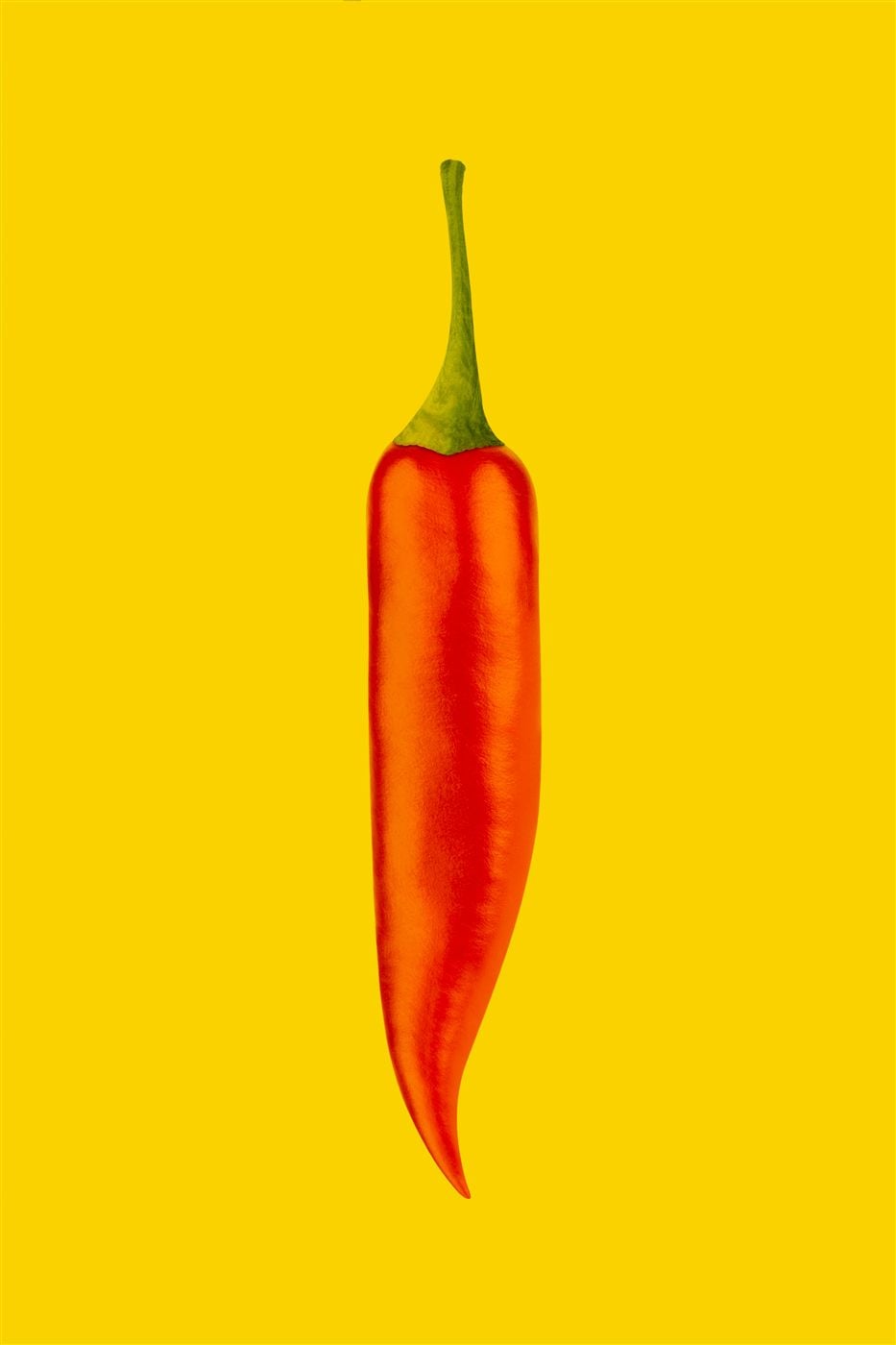 Un chile rojo sobre fondo amarillo